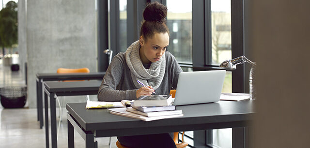 Young Female Student Taking Notes For Her Study
