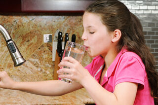 A Little Girl Getting A Glass Of Water