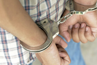 photo - Young man in handcuffs