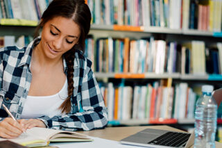 Female Student Using Laptop For Taking Notes To Study.