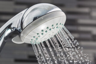 Shower Head With Water Drops Falling On A Bathroom