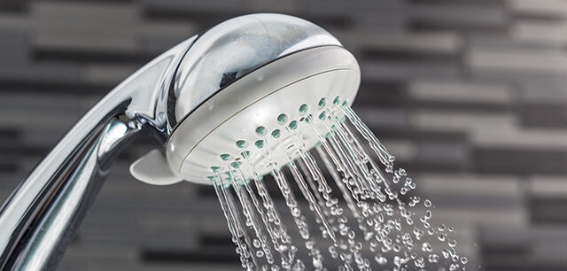 Shower Head With Water Drops Falling On A Bathroom
