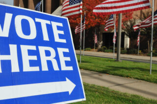 Vote Here Sign and American Flags