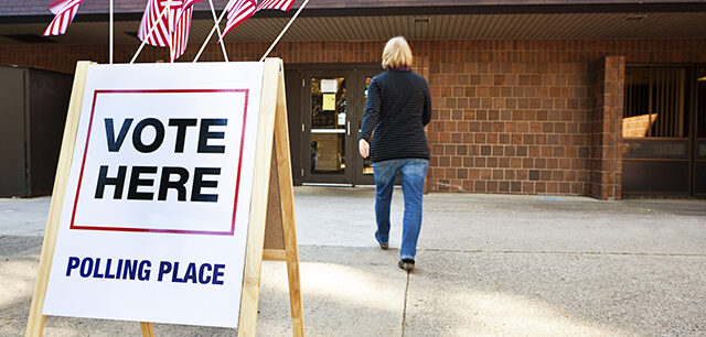 Woman Voter Entering Voting Polling Place For USA Government Election