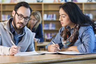 Adult Students Studying Together In College Library