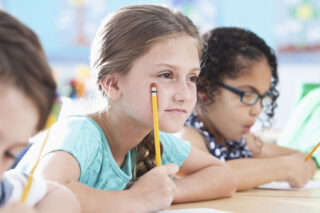 Elementary School Children Writing In Class