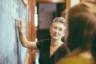 Teacher Professor Student At Chalkboard