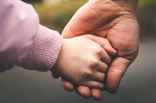 Father and child holding hands