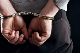 photo - Outlaw's Hands Locked In Handcuffs