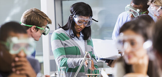Students Doing Experiment In Chemistry Class