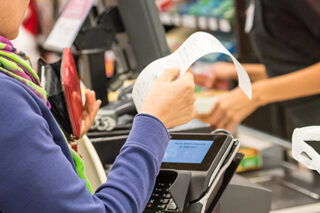 Woman electronic signing her bill at the supermarket