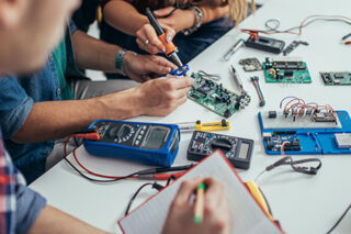 Group of students engineers working on a computer part