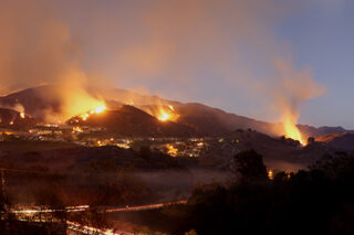 photo: A collection of fires burning across the hillside near homes In Portola Hills, California.