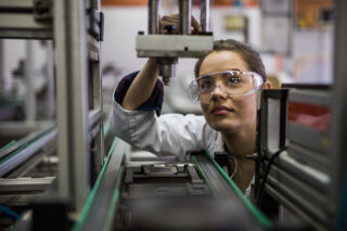photo - Female Engineer Examining a Machine