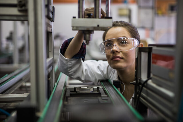 photo - Female Engineer Examining a Machine