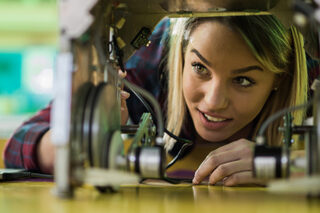 Happy Woman Examining A New Robot In Laboratory.