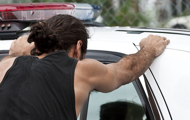 photo - Man with His Hands on Top of a Police Car