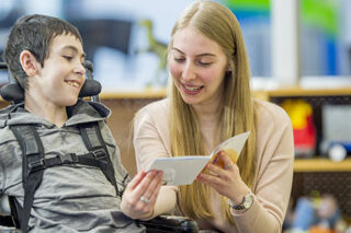 photo - Student in Wheelchair Being Read a Book
