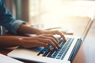 Photo of a person working on their laptop
