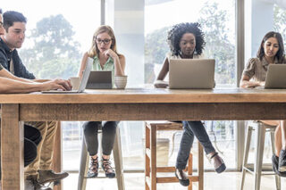 photo - Business People Working at High Desk Using Laptops