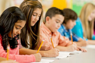 photo - Row of Elementary Students Working on an Assignment
