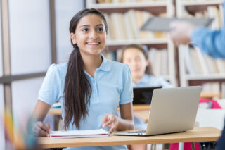 photo - Student at Desk with Laptop in Classroom