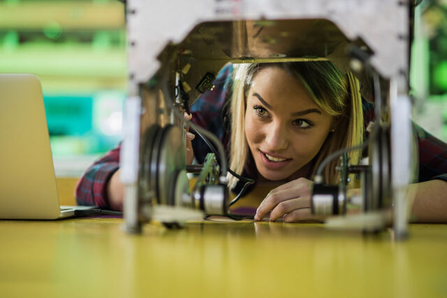 photo - Young Woman Examing Machinery