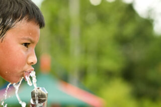 Boy Drinking From Water Fountain on Hot Day