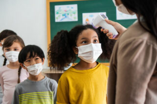Kids in masks in line for temperature check