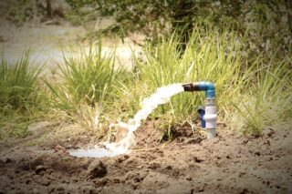 photo - Water Being Pumped Out on Agricultural Land Using Pump and Motor