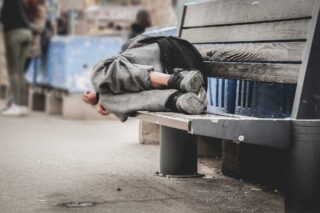 photo - homeless man sleeping on a bench