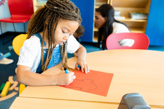 photo - Kindergartner Drawing in Classroom