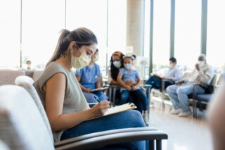 photo - Patient in Waiting Room Completing Paperwork