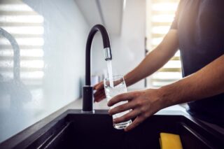 photo - Water Faucet with Hand and Glass