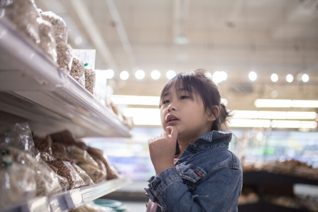 photo - Asian-American Girl Choosing Food in Supermarket