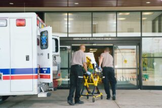 photo - Paramedics Taking Patient on Stretcher from Ambulance into Hospital