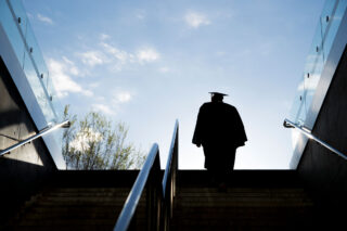 photo - Silhouette of College Graduate Climbing Steps