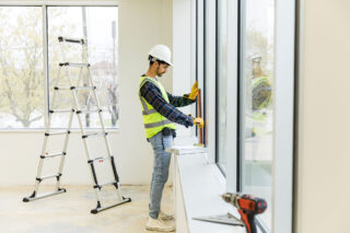 photo - Young Adult Male Construction Worker Working Inside an Empty Building