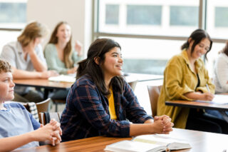photo - Young College Students Sitting in Classroom and Listening to Unseen Teacher