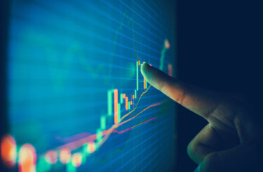 Finger pointing to stock market graph