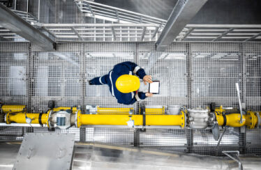 Worker walking by pipes
