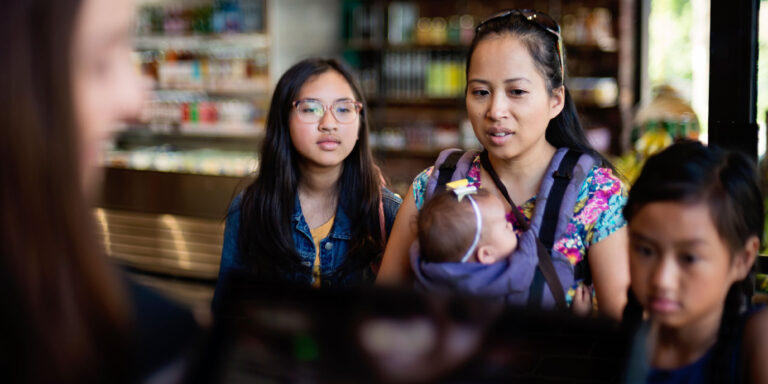 photo - Mother and daughters at check out counter