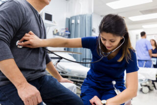 photo - Nurse Checks Heartbeat of patient in Emergency Room of Hospital
