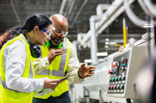 photo - Workers in Factory Looking at Machine Control Panel