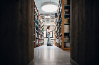 photo - Student Choosing Books on the Bookshelf