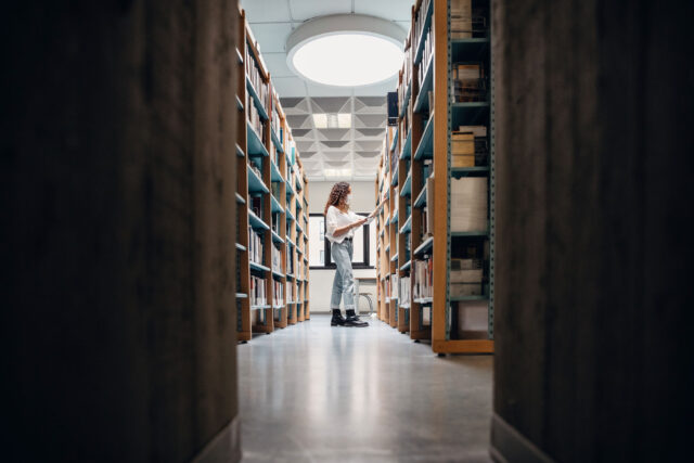 photo - Student Choosing Books on the Bookshelf