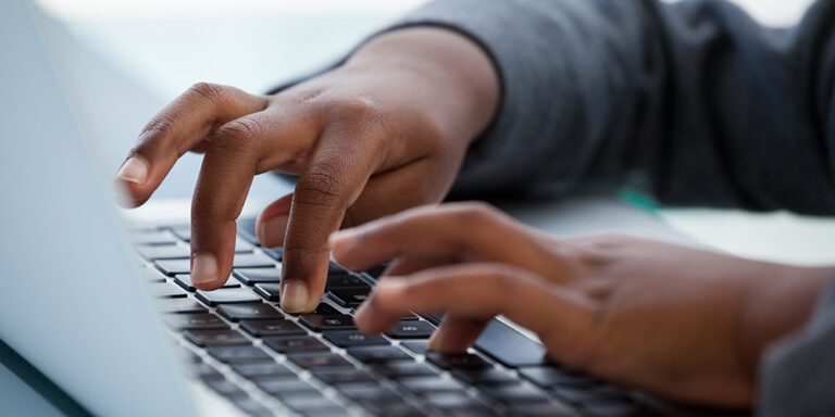 photo - Close Up of Child Typing on Laptop