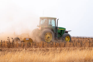 photo - tractor plowing in a dry field