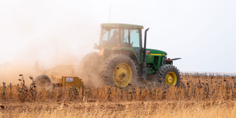 photo - tractor plowing in a dry field