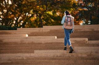 photo - Female Student Walking Up the Staircase Outdoors